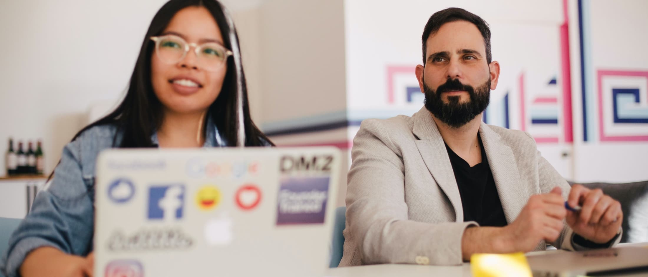 Two people sitting at a table smiling at the camera.