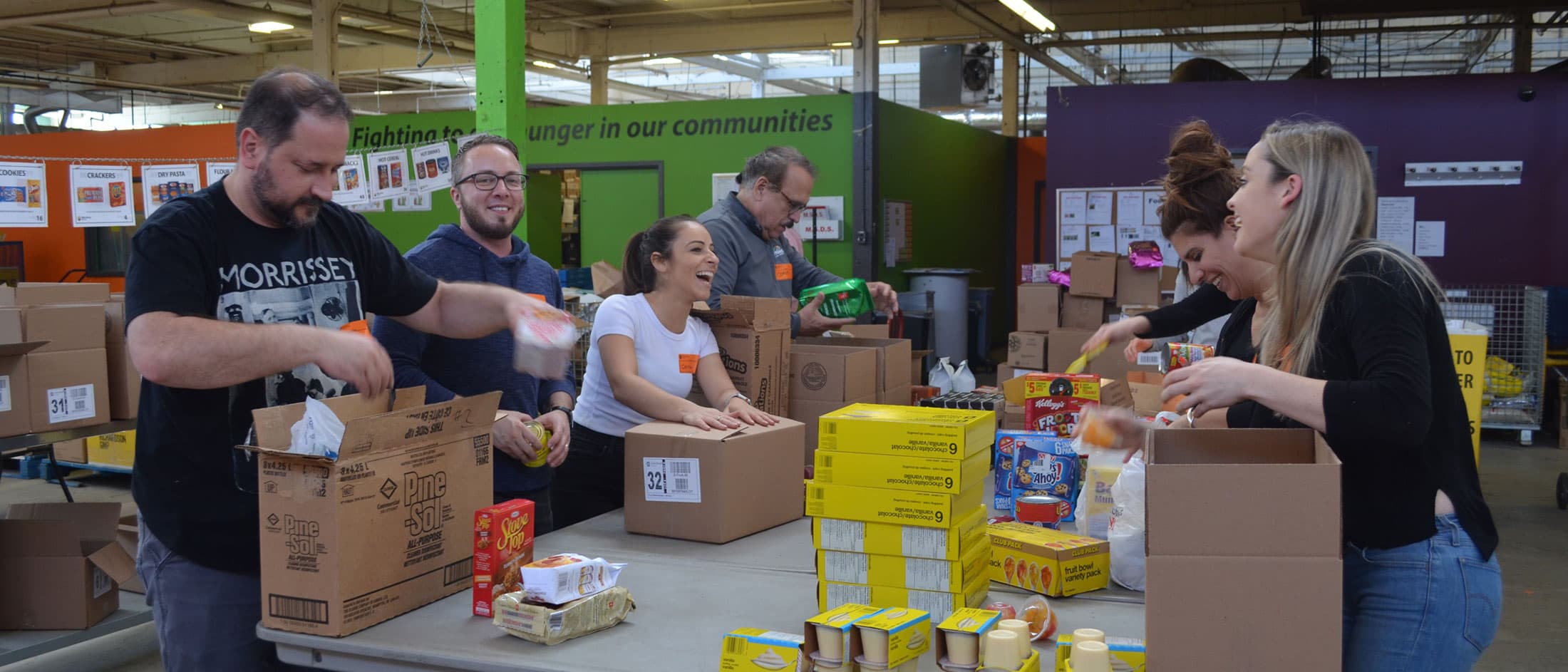 Group of people placing foods in boxes