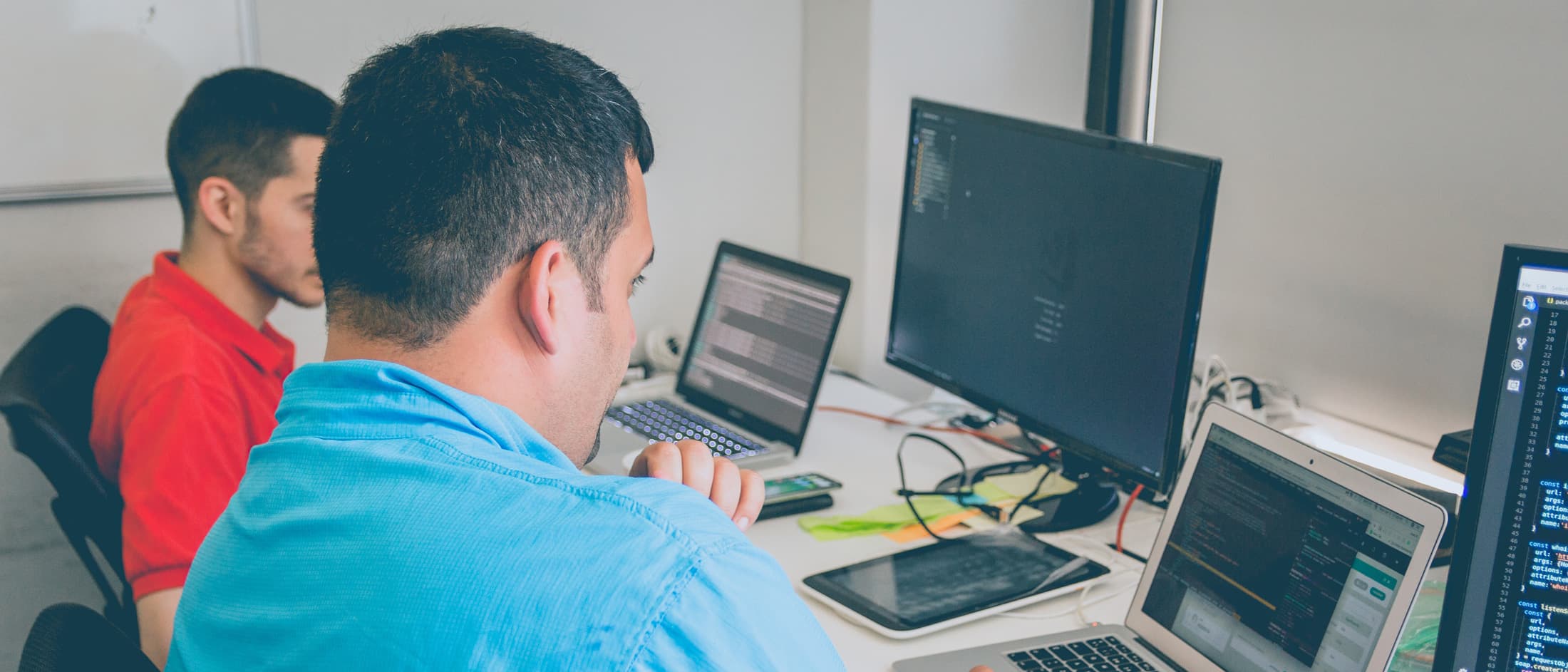 Two individuals working on computers