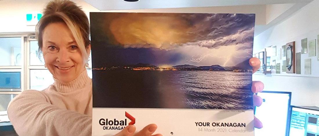 An individual holding Your Okanagan calendar 