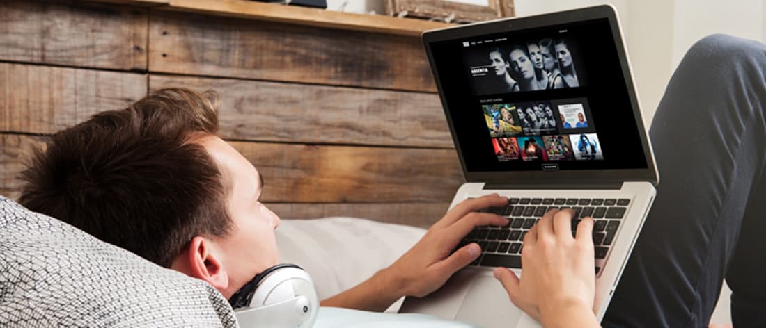 Man lying down looking at site on laptop