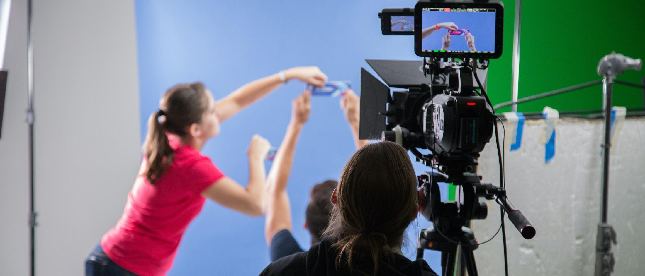 Person filming a set with bluescreen background